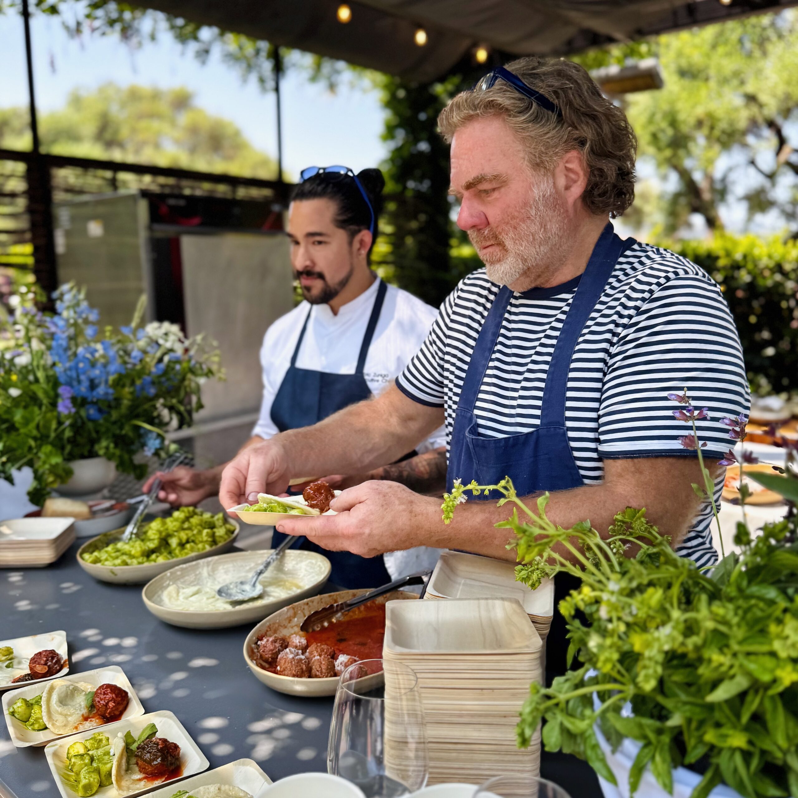 Two chefs preparing dishes at event